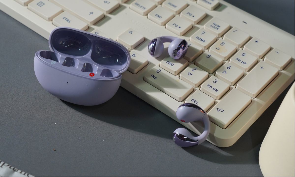Lila kabellose Kopfhörer mit Ladecase auf weißer Tastatur – intuitive Steuerung & Komfort für bessere Benutzererfahrung.